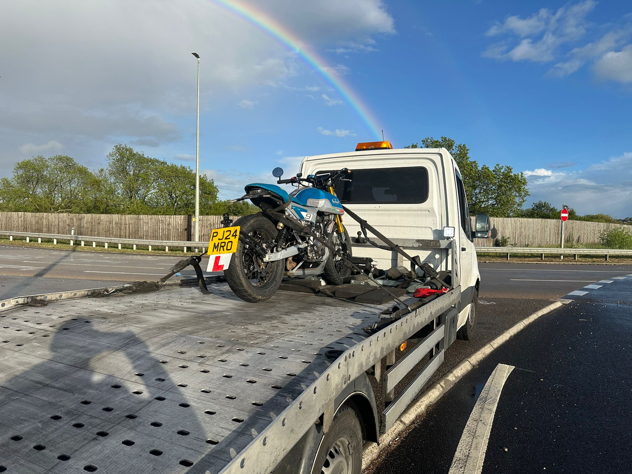 Motorcycle recovery on UK road with rainbow — Awan Recovery MK